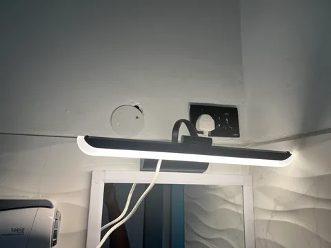 A light mounted above the bathroom mirror with a shaver socket nearby at Wangs BnB.