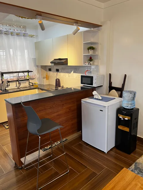 Breakfast counter with stools beside Nova’s kitchen and refrigerator.