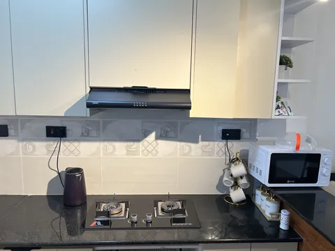 Nova cooking hob beneath an extractor, with a kettle, microwave and cups alongside.