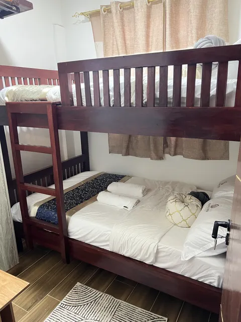 Wooden bunk bed with white bedding and folded towels in Nova’s second bedroom.